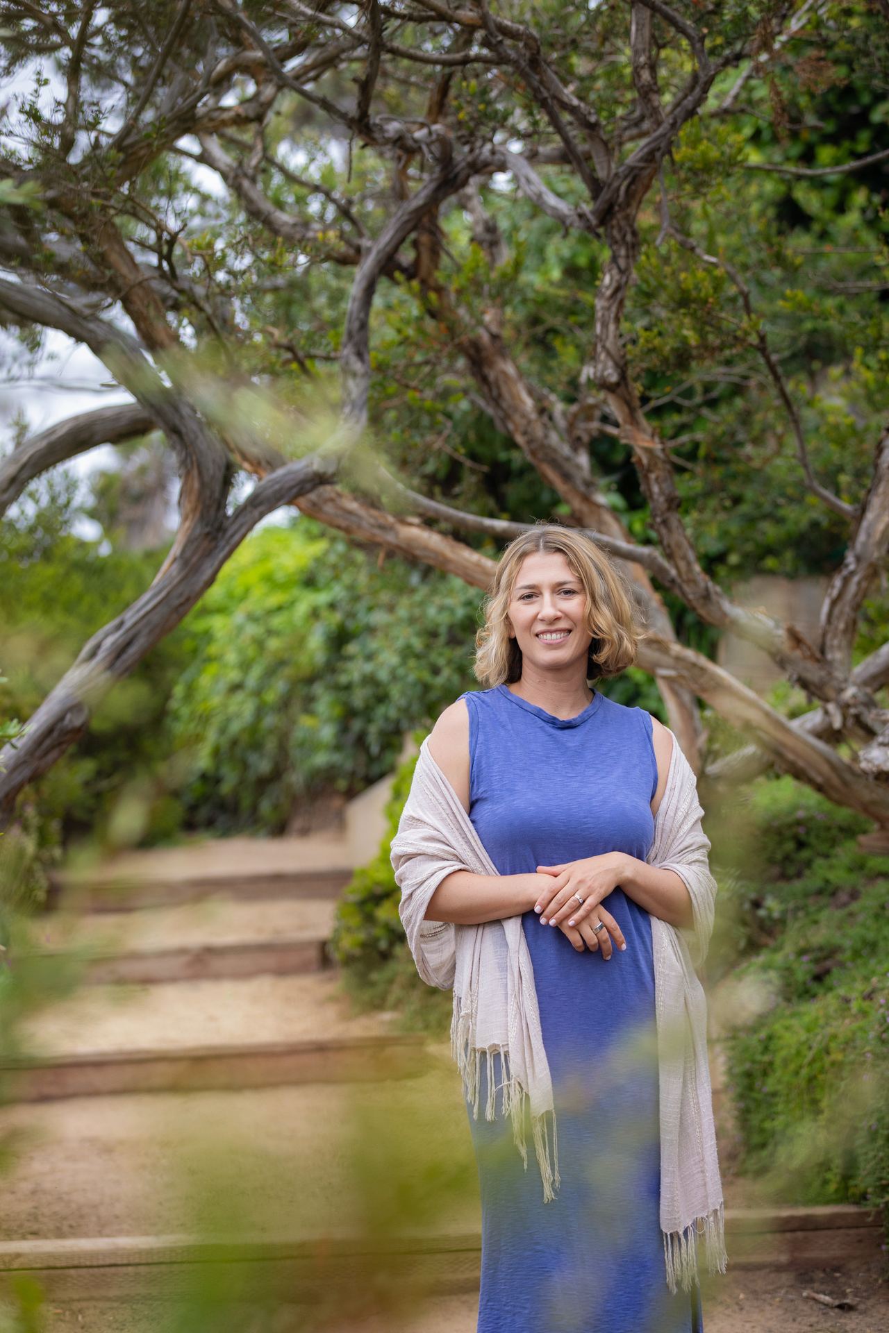 Vera McGrath, Licensed Marriage and Family Therapist, standing on a tree-lined path in Carlsbad